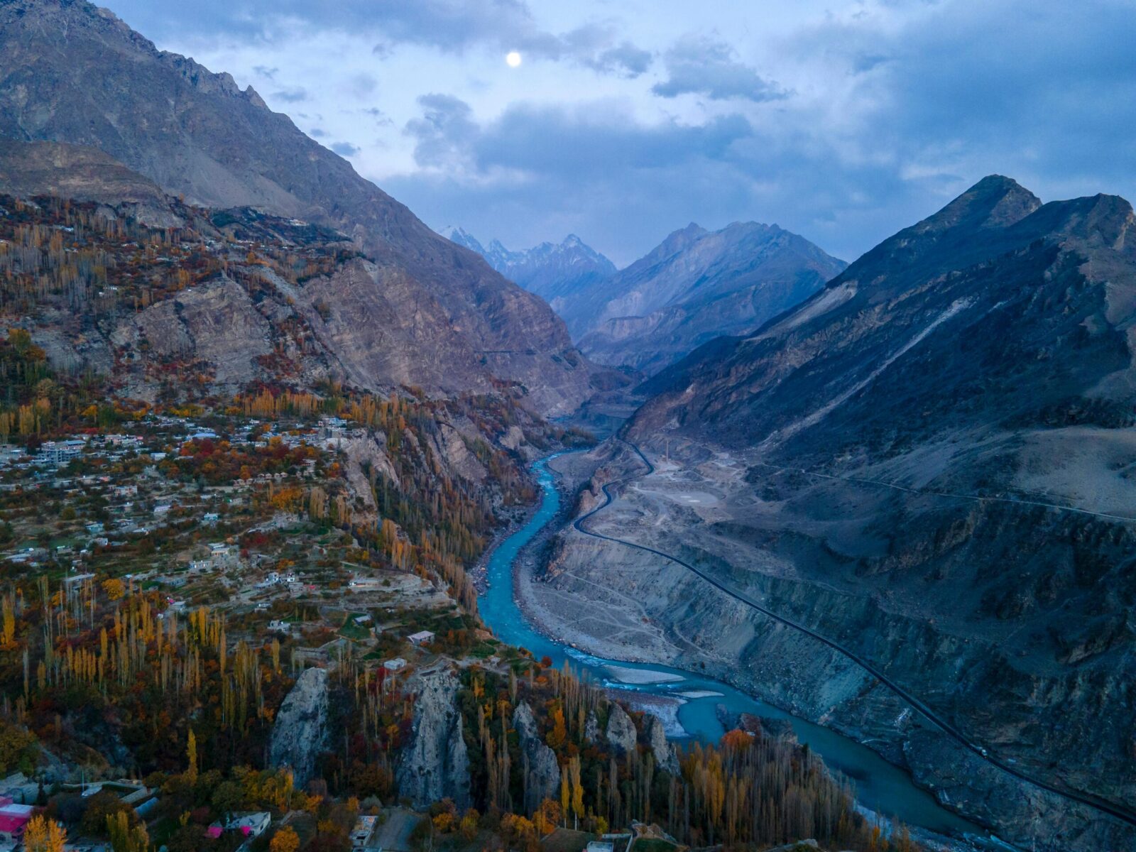 Stunning aerial view of the Hunza Valley with autumn foliage and a winding river in Pakistan.